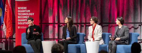 Moderator speaks with panel on stage